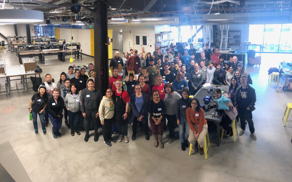 A large group of toy hackers from Provail Therapy Center, the UW Taskar Center for Accessible Technology, HuskyADAPT, Global Innovation Exchange, and PNW library volunteers smile at the camera at the 2019 Holiday GIX Hackathon.